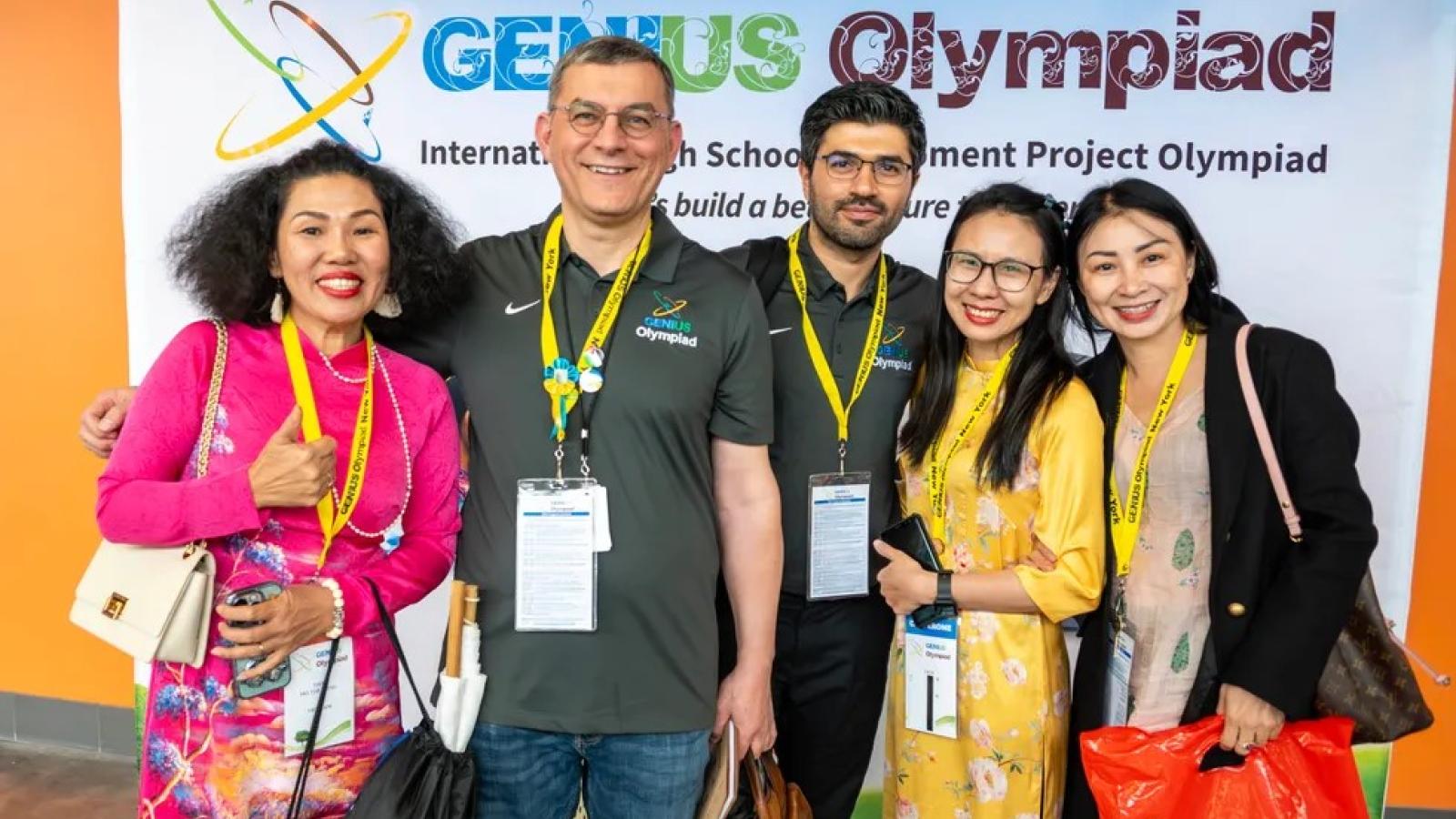 Dr. Fehmi Damkaci stands with four people in front of a Genius Olympiad backdrop