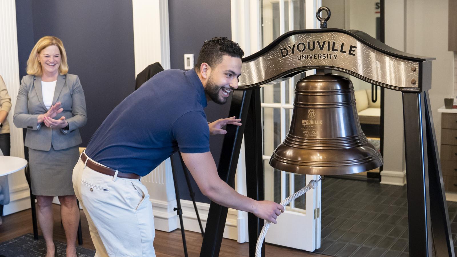 John Rizk rings the new D'Youville University victory bell