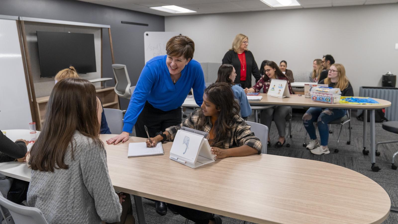 Faculty interacts with student while they participate in an activity