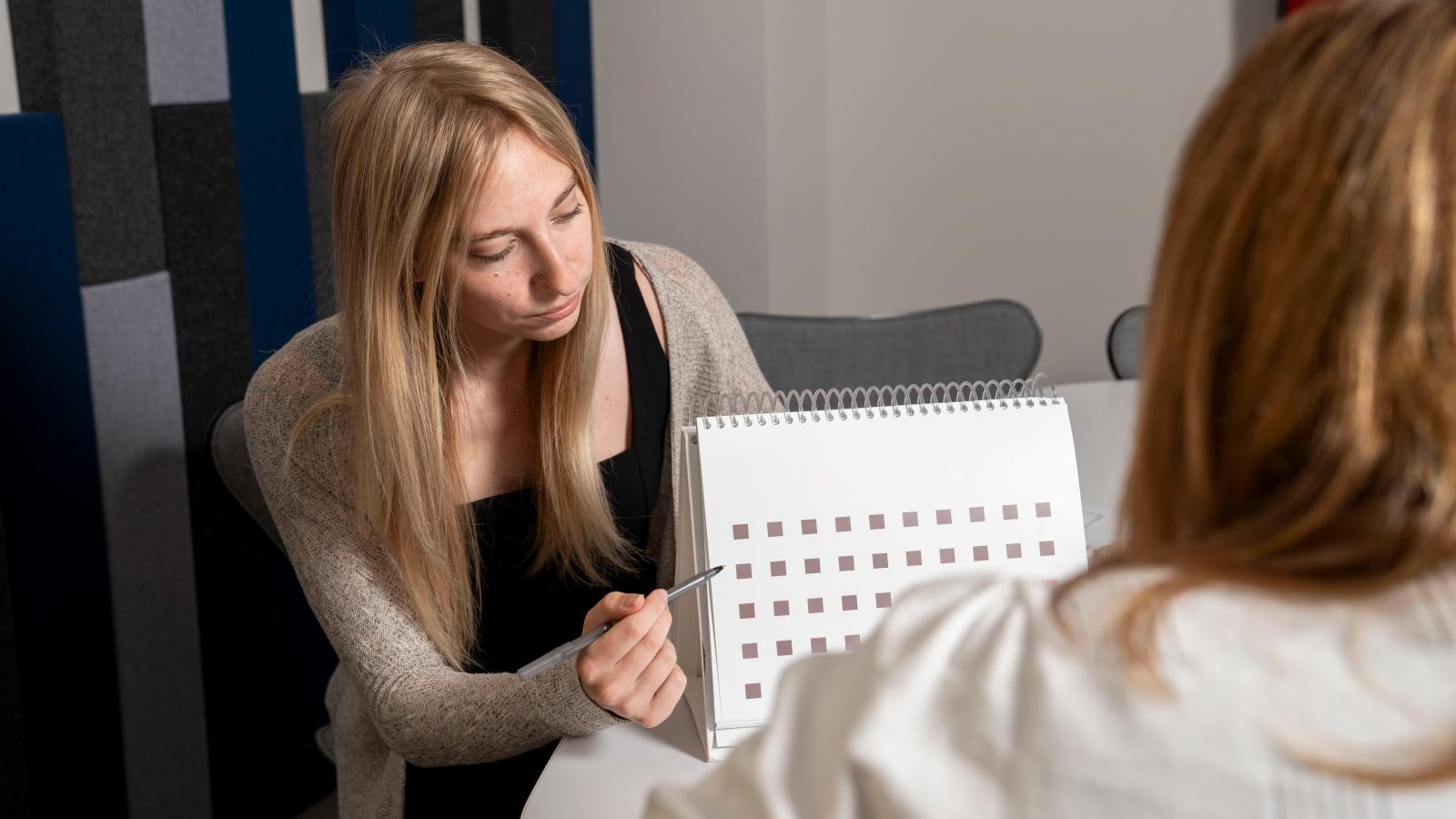 woman points at squares on document
