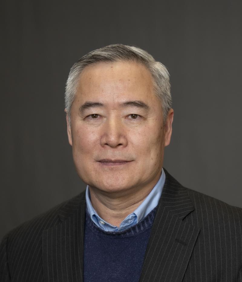 Man in suit jacket smiles at the camera