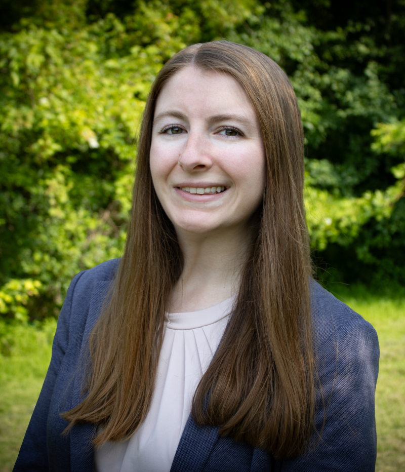 woman smiles at the camera wearing a suit jacket