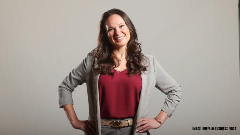 woman stands with hands on hips smiling at the camera