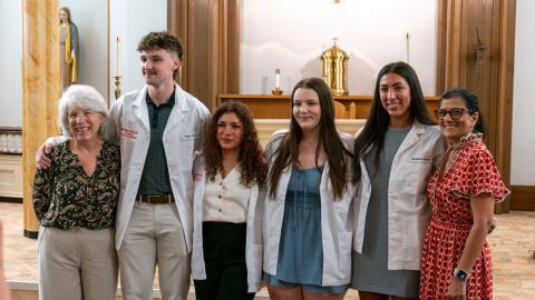 a line of people stand smiling at the camera