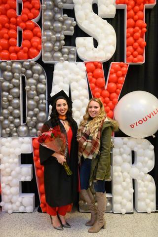 Two female students stand in front of a Best Day ever balloon display.
