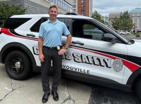 Campus Safety officer standing by vehicle.