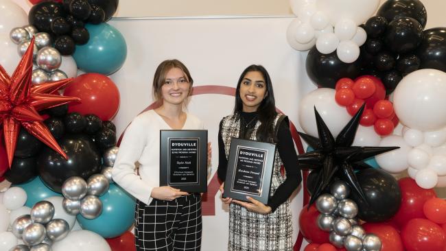 Two students holding up their awards at honors convocation