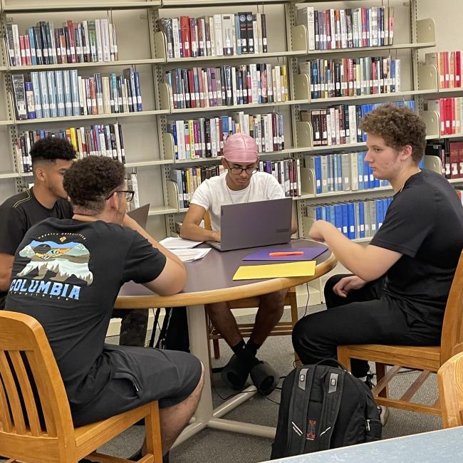 A group of young male students study together in the montante family library