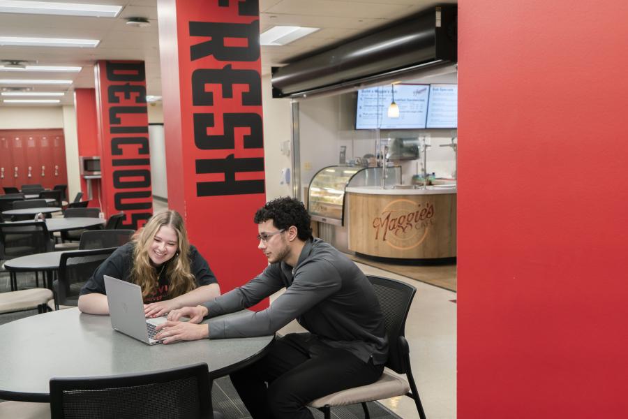 Two students sit at a table inside Maggie's Cafe