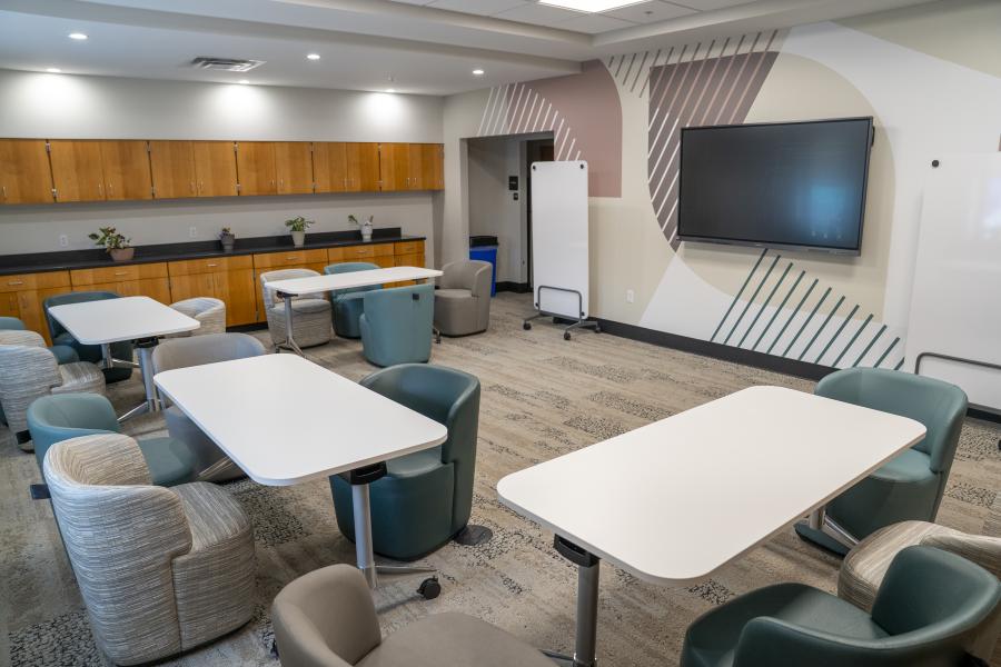 large conference room with long tables with comfortable chairs arranged in a semi-circle