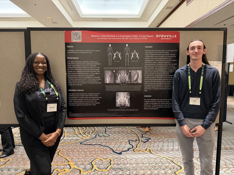 Two people stand to the left and right of a scientific research poster.