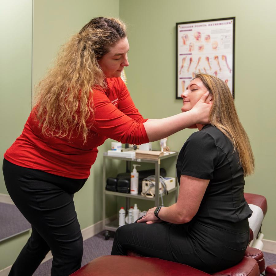 woman performs chiropractic adjustment on patient