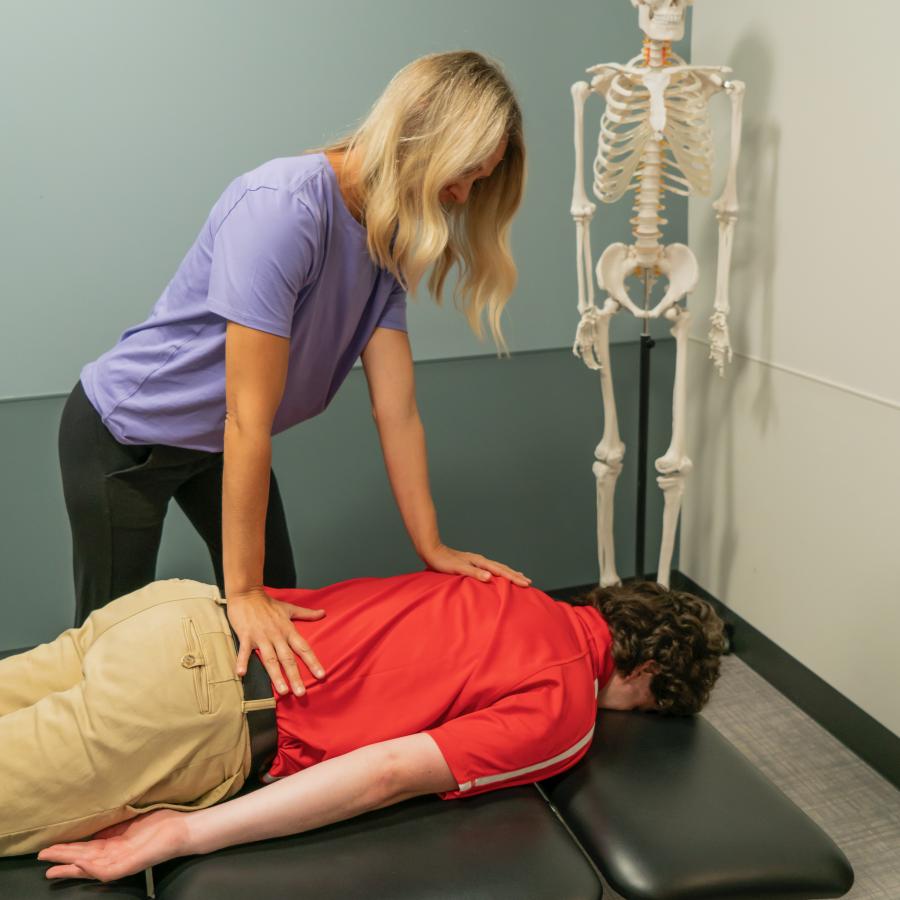 woman performs chiropractic adjustment on patient