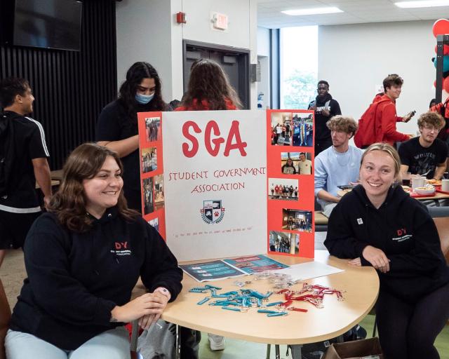 Two female students representing the Student Government Association at their Club Fair table