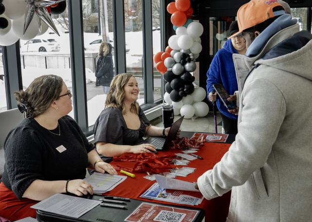 smiling women checking guests in at a desk