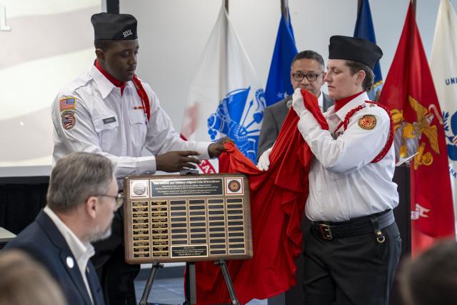 honor guard uncovers plaque with names of each student honored