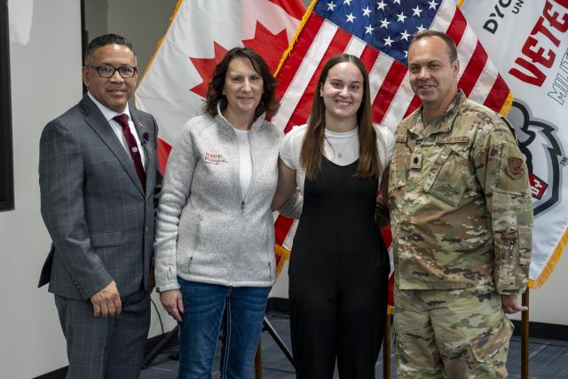 group of four people stand smiling at the camera