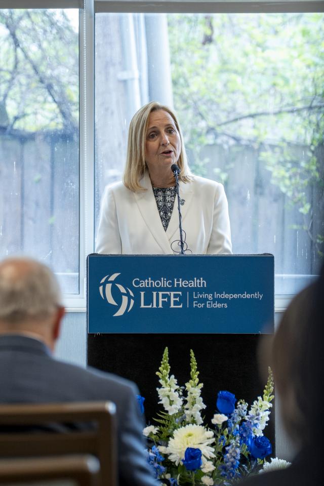 joyce standing at a podium speaking