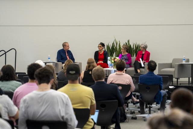 audience watching a panel discussion on a stage