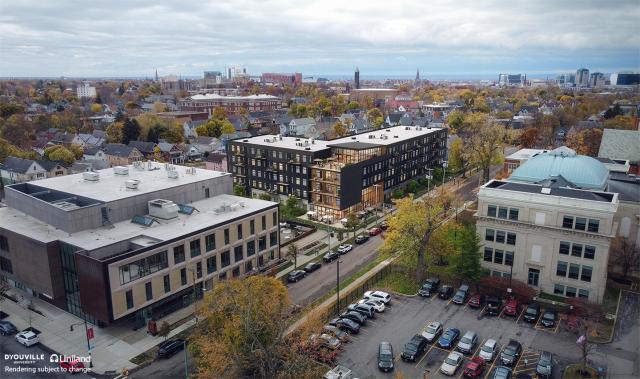 Aerial view of three large buildings in the foreground with others in the distance.