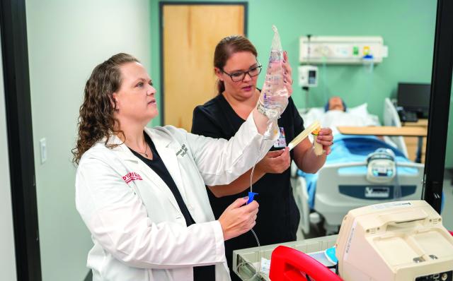 the nursing dean and simulation director in the lab looking over equipment