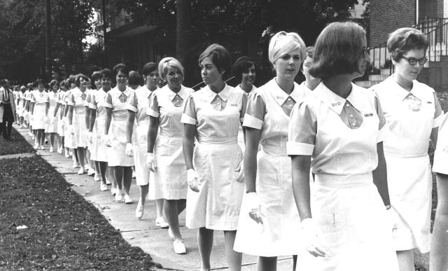 1966 photo of nursing students standing in line before a ceremony
