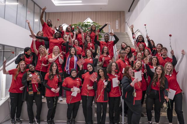group photo of nurses in red scrubs cheering