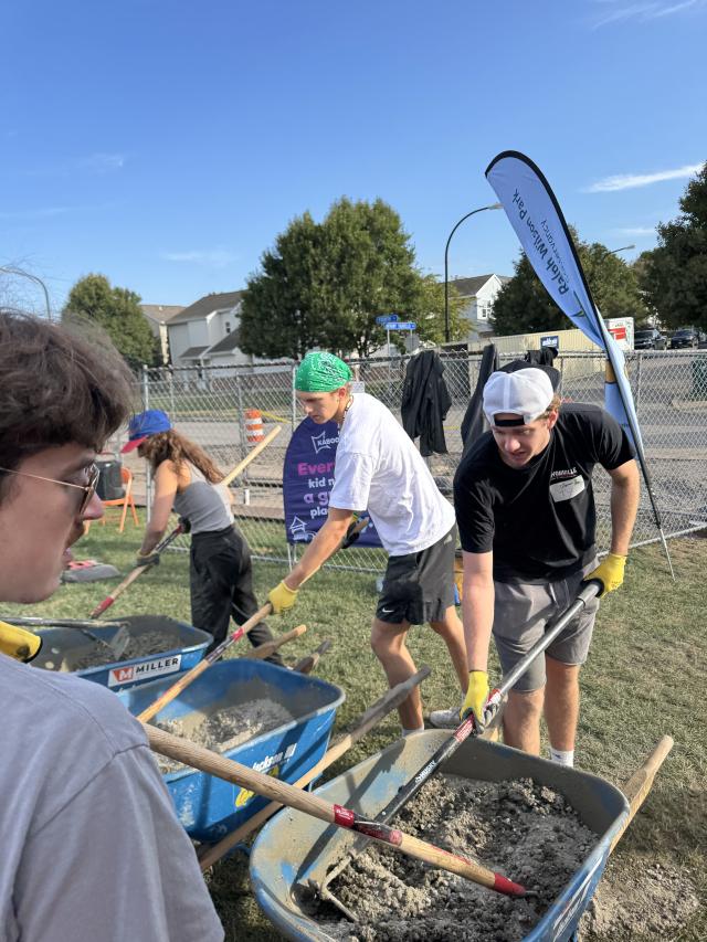 three people using shovels to mix concrete in wheelbarrows