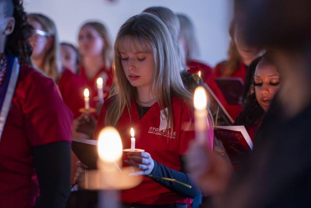 students hold candles while reading the nursing pledge