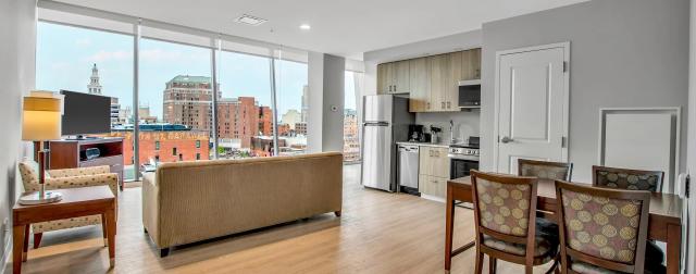 apartment living and kitchen space, view outside window overlooks a cityscape.