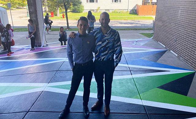 Matt Wild and Casey Milbrand pose on the As Is mural.