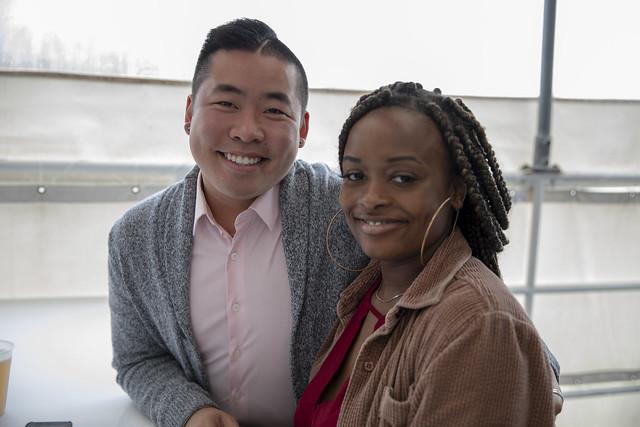 A male and female student smile for the camera while standing on the deck of a boat