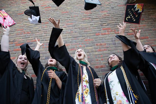 Students tossing graduation caps in the air.
