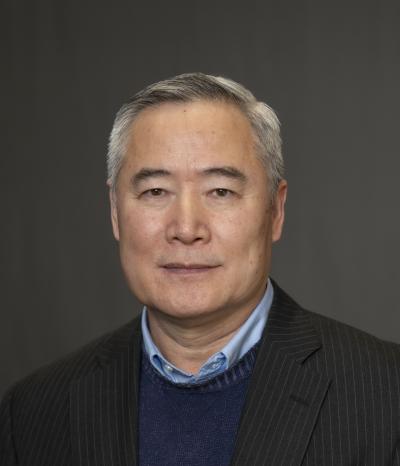 Man in suit jacket smiles at the camera