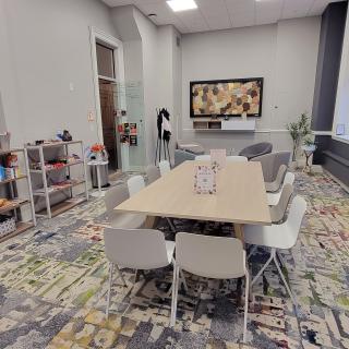 a meeting space with a large conference table in the center